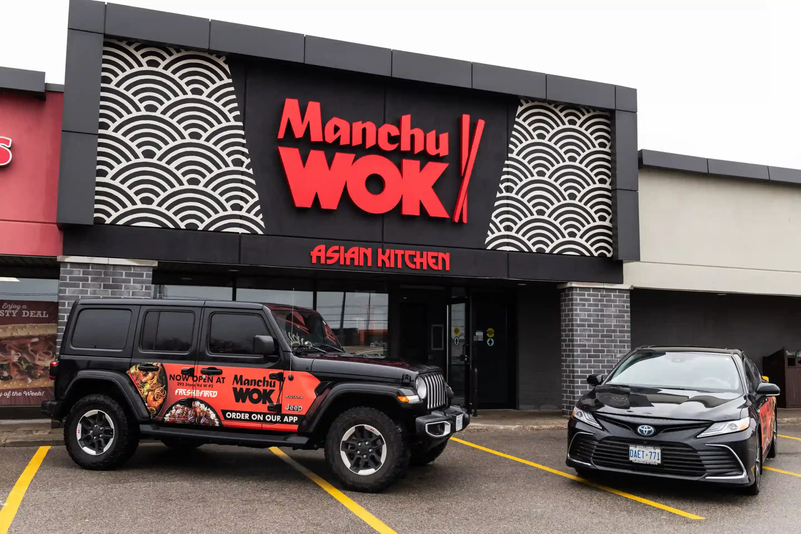 Top view of Manchu WOK takeout boxes filled with noodles, vegetables, and crispy chicken; a vibrant, authentic Chinese food franchise experience celebrating Asian flavours in Canada. | MTY Group Franchising
