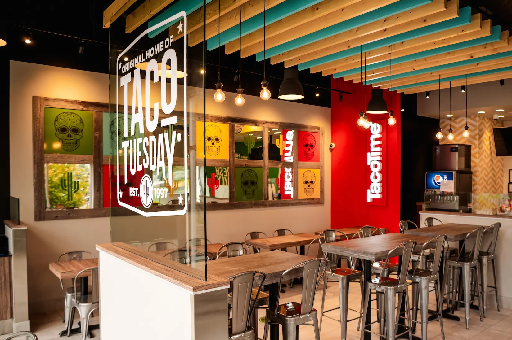 Interior of a Taco Time restaurant in Canada featuring industrial-style seating, and modern pendant lighting